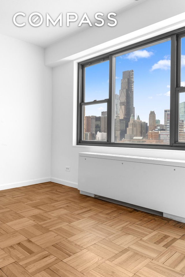 empty room with a view of skyline and baseboards