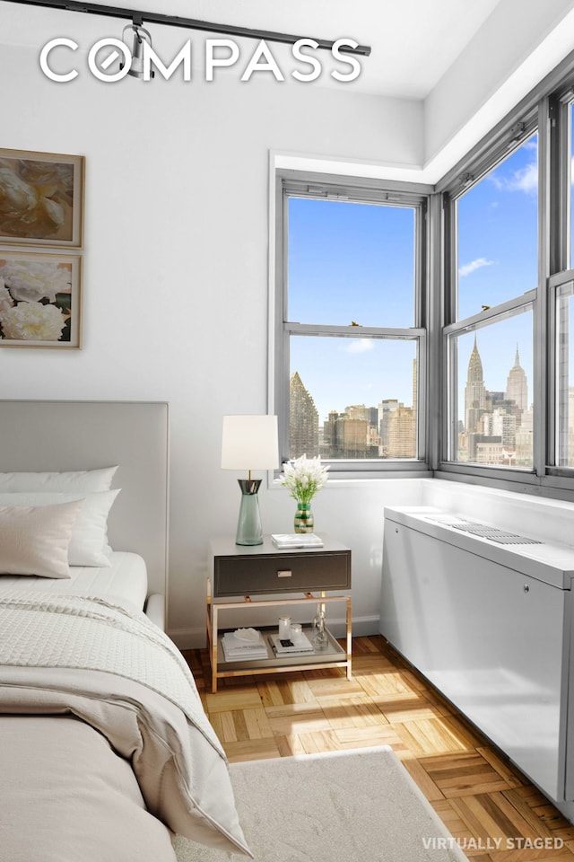 bedroom with a view of skyline and baseboards