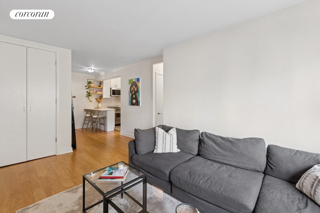 living area with light wood-style flooring and baseboards