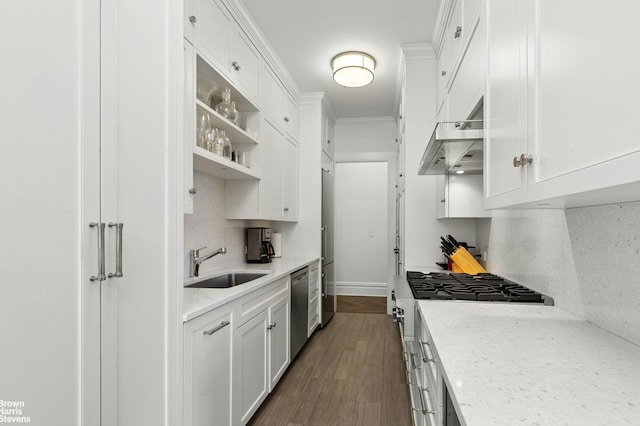 kitchen with a sink, gas range oven, white cabinetry, backsplash, and crown molding