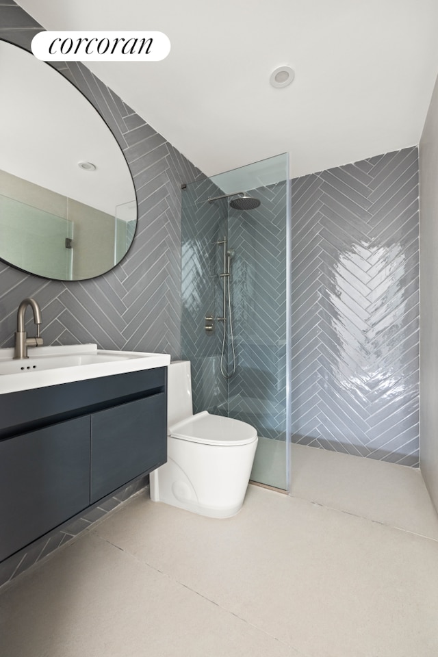 full bathroom featuring tile walls, walk in shower, toilet, and vanity