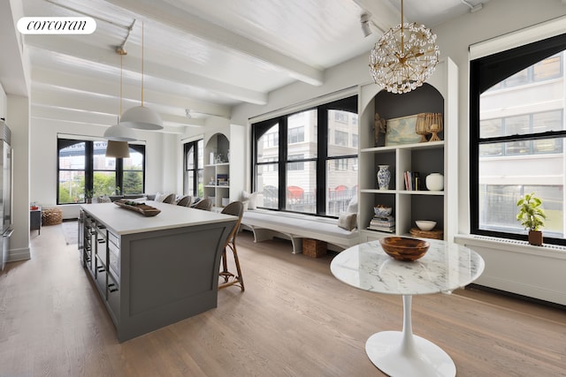 dining room with beamed ceiling, wood finished floors, and a chandelier