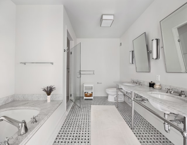 full bathroom featuring toilet, a shower stall, a garden tub, double vanity, and baseboards