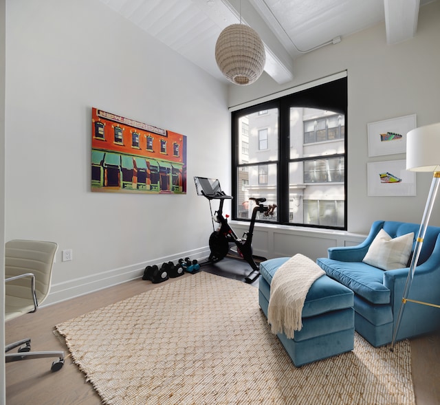 exercise room with wood finished floors and baseboards