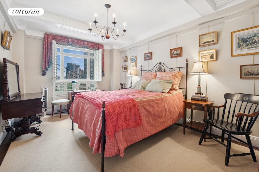 bedroom with ornamental molding, a chandelier, and carpet