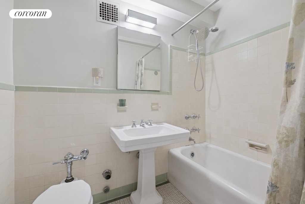 2 Beekman Pl Unit 12D, New York City, NY 10022 - full bath featuring tile walls, shower / bath combination with curtain, and toilet