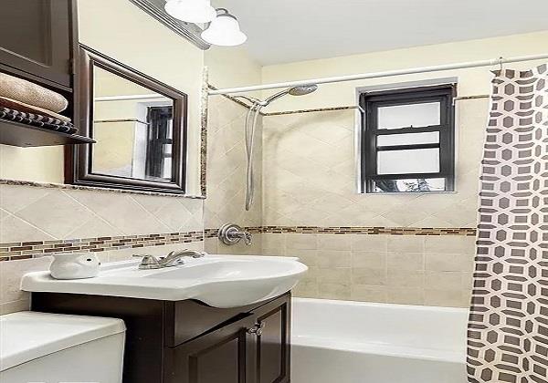21-67 33rd St Unit F-4, New York City, NY 11105 - full bathroom with shower / bath combination with curtain, vanity, toilet, backsplash, and tile walls