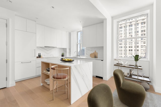 1 Wall St Unit 3212, New York City, NY 10005 - kitchen featuring modern cabinets, light wood-style floors, dishwashing machine, light countertops, and a center island
