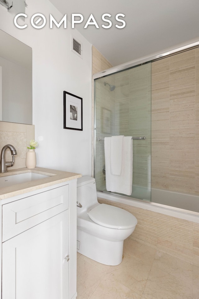 bathroom with tiled shower / bath combo, vanity, and toilet