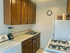 166-30 17th Rd Unit 2, New York City, NY 11357 - kitchen featuring washer / clothes dryer, freestanding refrigerator, a sink, range, and light countertops