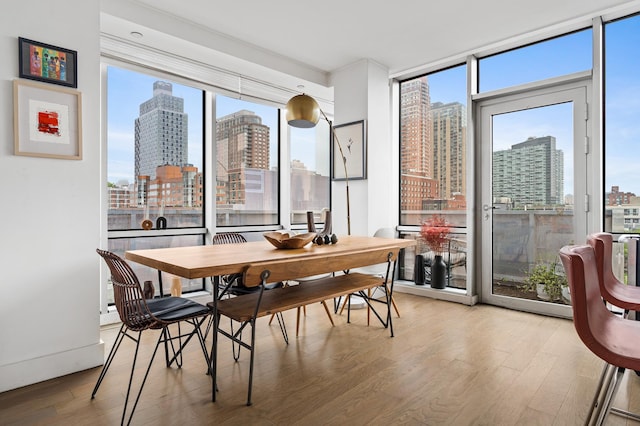 5-19 Borden Ave Unit 7-A, New York City, NY 11101 - dining area with a skyline view, wood finished floors, and a wall of windows