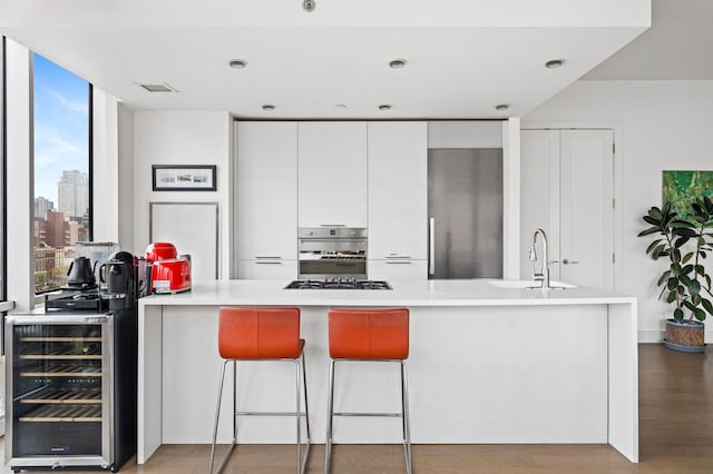 5-19 Borden Ave Unit 7-A, New York City, NY 11101 - kitchen with a sink, stainless steel appliances, modern cabinets, white cabinetry, and wine cooler