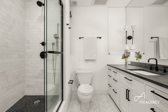 full bath featuring a stall shower, toilet, vanity, tile patterned flooring, and baseboards