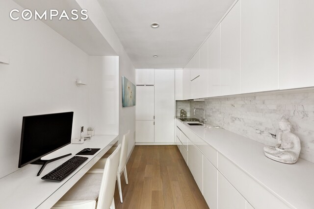 48 Gramercy Park N Unit 1A, New York City, NY 10010 - kitchen with light wood-style floors, modern cabinets, white cabinets, and a sink
