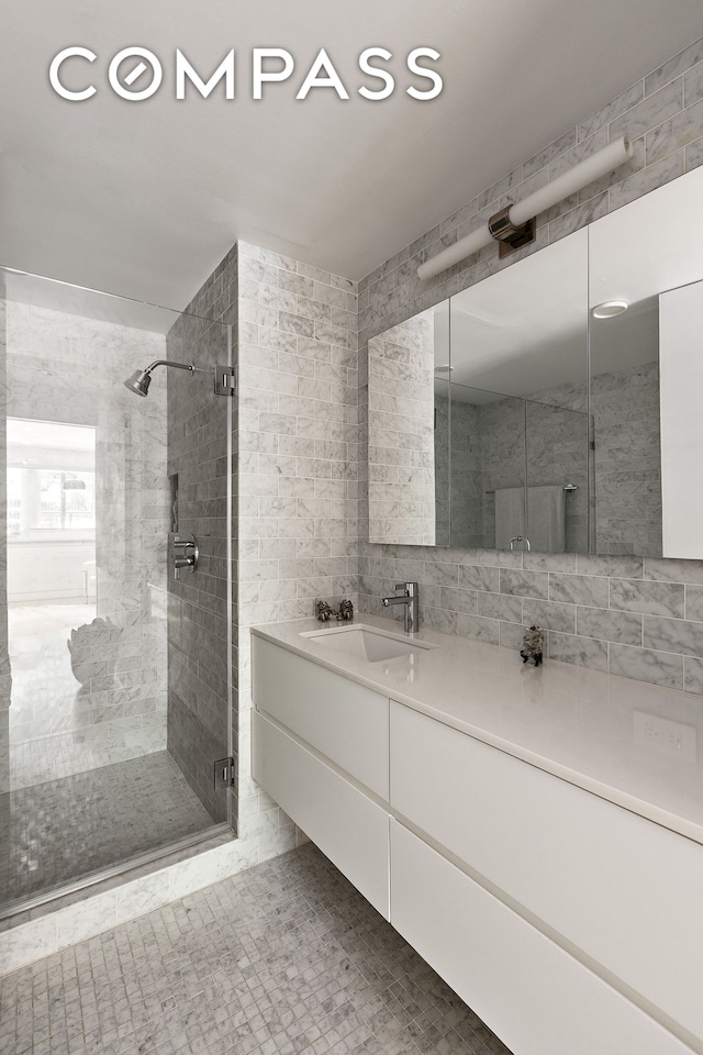 48 Gramercy Park N Unit 1A, New York City, NY 10010 - bathroom featuring a stall shower, vanity, and tile walls