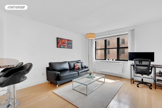 516 W 47th St Unit S4M, New York City, NY 10036 - living room featuring wood finished floors, an office area, and radiator