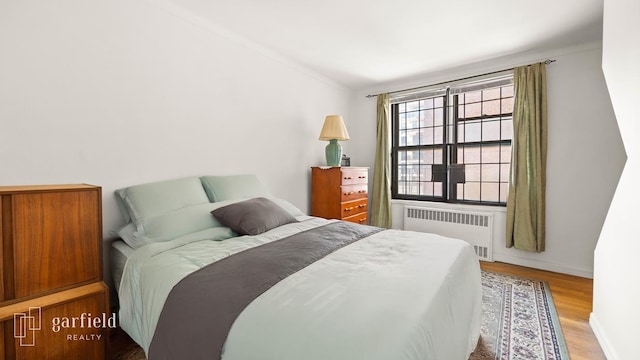 61 Oliver St Unit 2-P, New York City, NY 11209 - bedroom featuring radiator, wood finished floors, and lofted ceiling