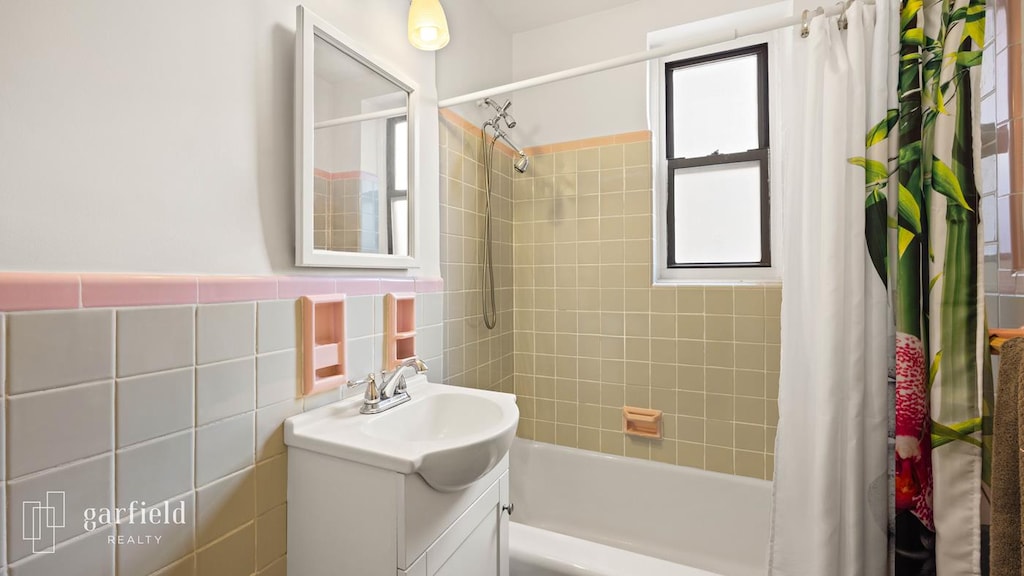 61 Oliver St Unit 2-P, New York City, NY 11209 - bathroom featuring plenty of natural light, vanity, shower / bath combo, and tile walls
