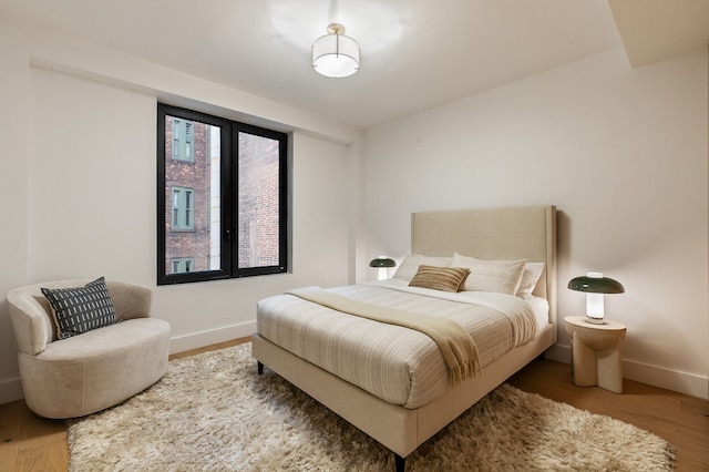bedroom featuring baseboards and wood finished floors