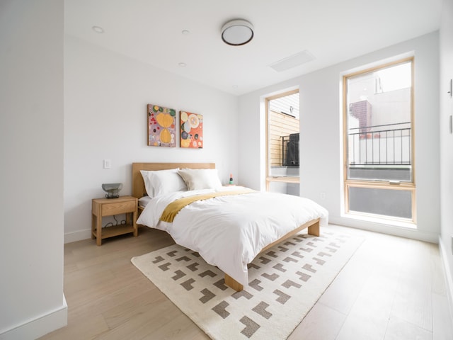bedroom with light wood-style flooring and baseboards