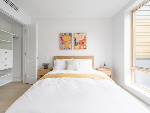 bedroom featuring wood finished floors and multiple windows