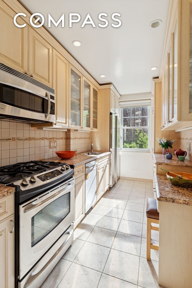 180 Cabrini Blvd Unit 54, New York City, NY 10033 - kitchen with stainless steel appliances, tasteful backsplash, a sink, light stone counters, and recessed lighting