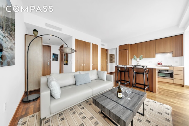living area featuring light wood finished floors and baseboards