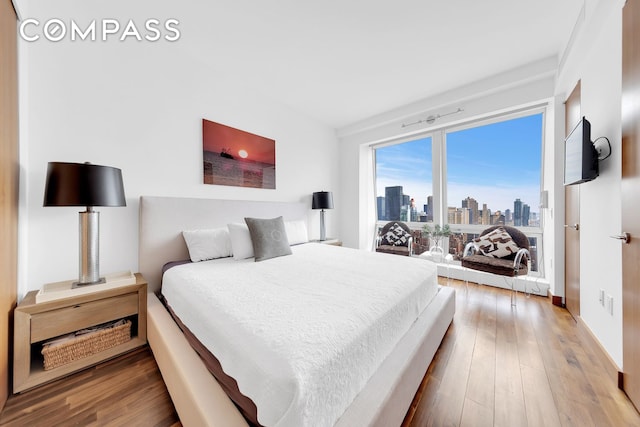 bedroom featuring wood finished floors and baseboards