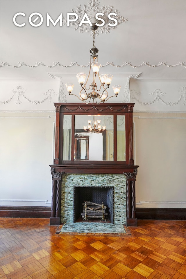 detailed view of a premium fireplace, a chandelier, and baseboards