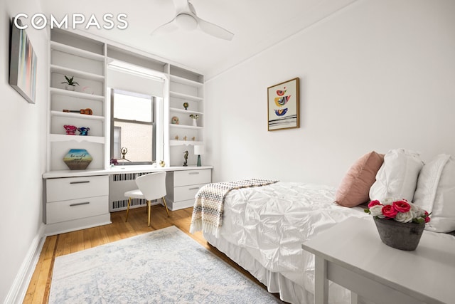 bedroom with radiator, light wood-style floors, ceiling fan, and baseboards