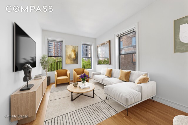 living room featuring light wood-type flooring and baseboards