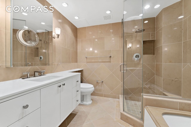 3 E 75th St Unit 1C, New York City, NY 10021 - bathroom with tile walls, vanity, a shower stall, toilet, and recessed lighting