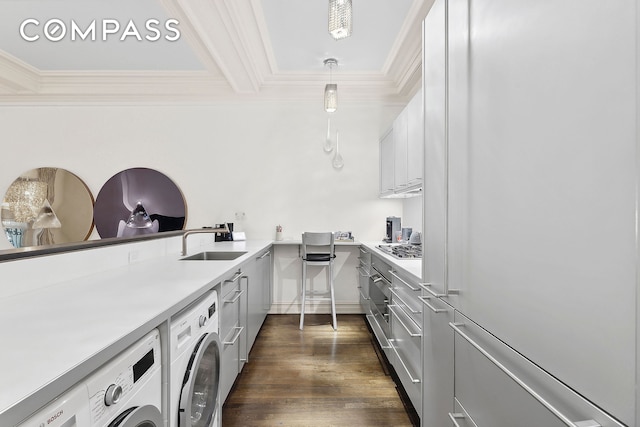 3 E 75th St Unit 1C, New York City, NY 10021 - washroom featuring washer and clothes dryer, ornamental molding, dark wood finished floors, and cabinet space
