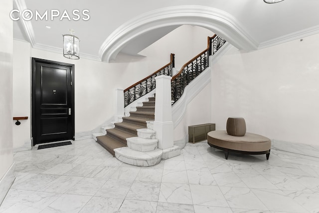 3 E 75th St Unit 1C, New York City, NY 10021 - entryway with marble look tile flooring, stairway, crown molding, and a chandelier