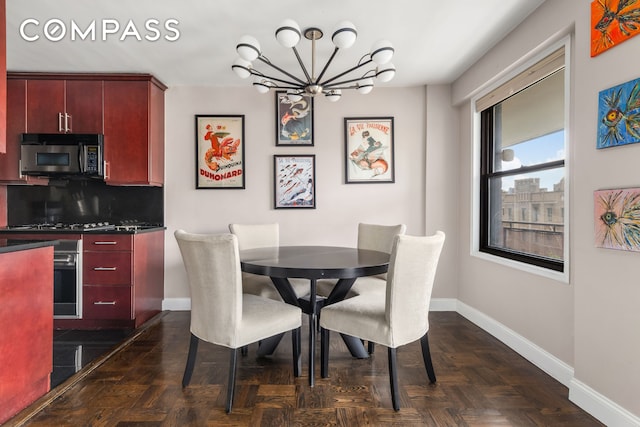 dining space with baseboards and a chandelier