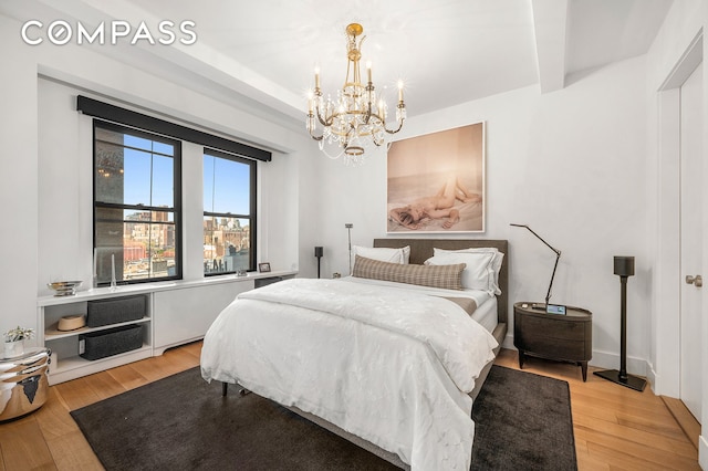 24 5th Ave Unit 824, New York City, NY 10011 - bedroom featuring a chandelier, light wood-style floors, and beam ceiling