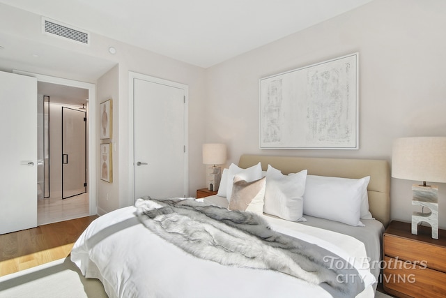 bedroom with wood finished floors and a closet