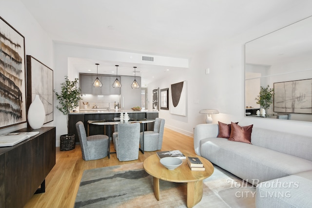 living area featuring light wood finished floors, recessed lighting, and baseboards