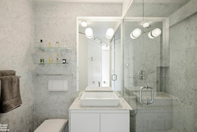 bathroom with a stall shower, double vanity, and toilet
