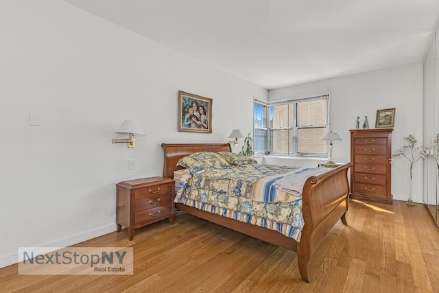 bedroom featuring wood finished floors and baseboards