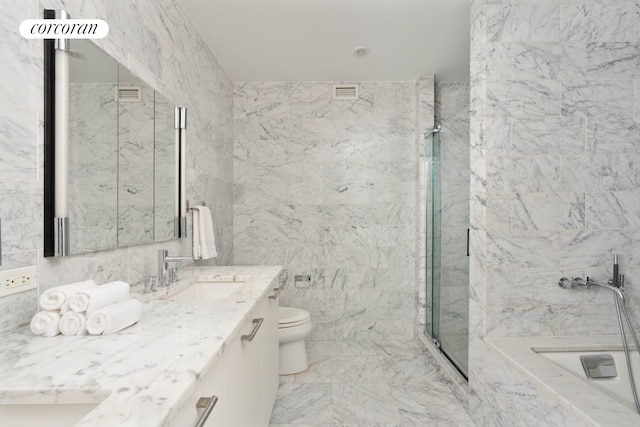 bathroom with a marble finish shower, a tub with marble appearance, vanity, toilet, and tile walls