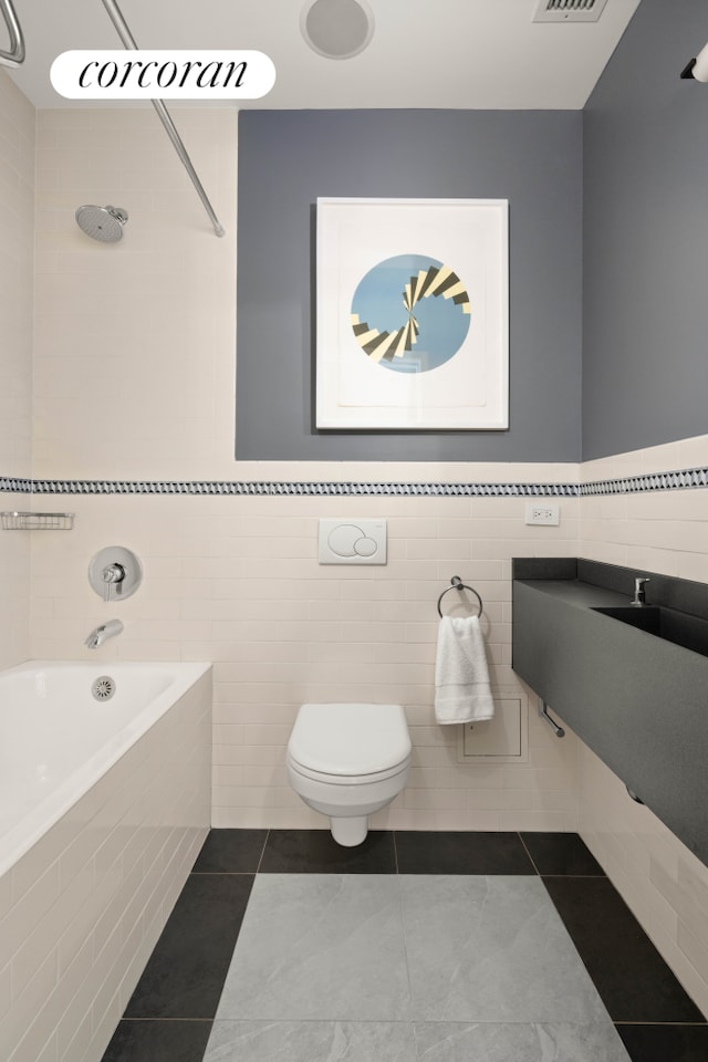 full bath with tile walls, toilet, and tile patterned flooring