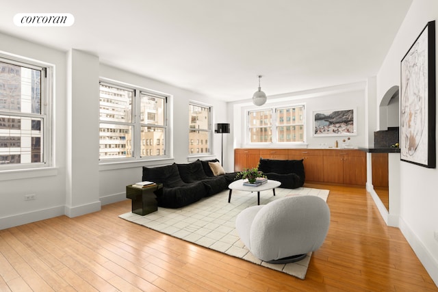 living area with light wood-style flooring and baseboards