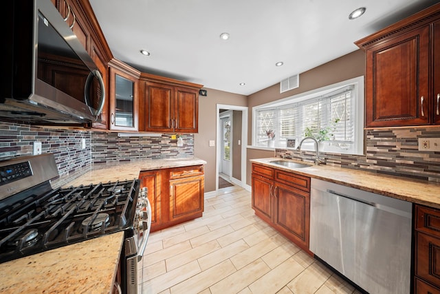 173-73 Croydon Rd, New York City, NY 11432 - kitchen featuring appliances with stainless steel finishes, a sink, decorative backsplash, recessed lighting, and light stone countertops