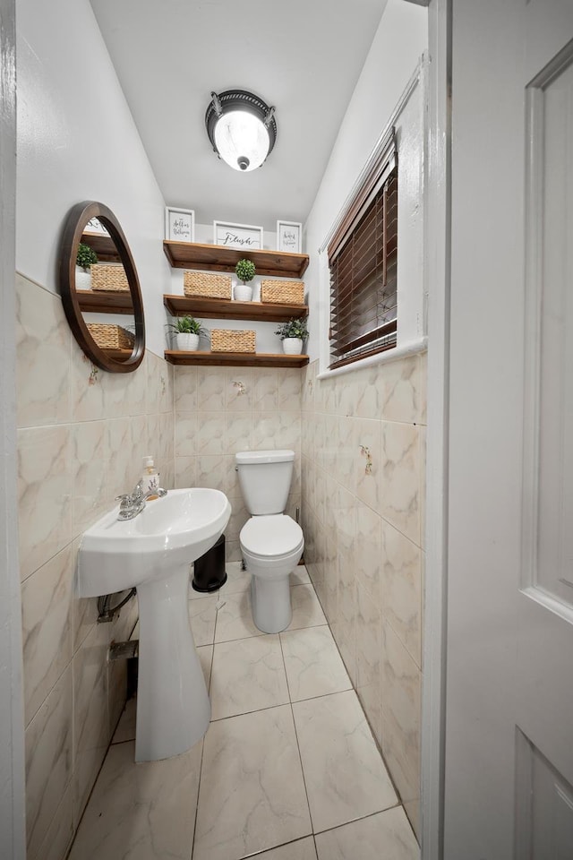 173-73 Croydon Rd, New York City, NY 11432 - half bath with marble finish floors, toilet, tile walls, and a wainscoted wall