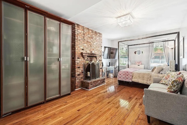 226 E 95th St Unit 201, New York City, NY 10128 - bedroom with light wood-style flooring and a fireplace