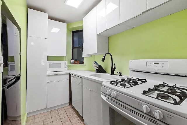 226 E 95th St Unit 201, New York City, NY 10128 - kitchen with white appliances, a sink, white cabinetry, and light countertops