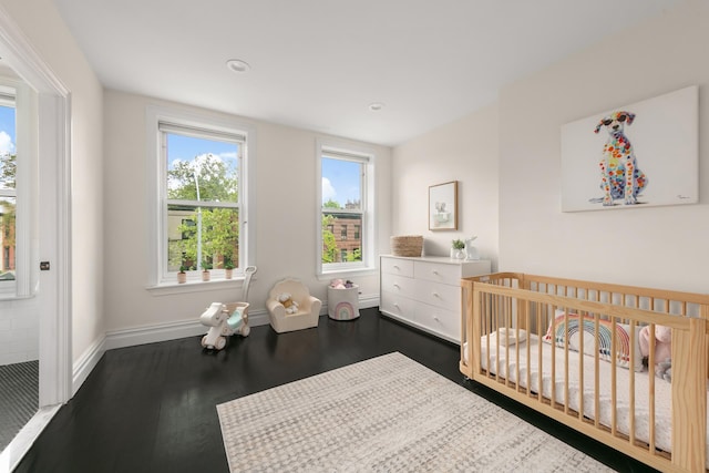481 Macon St, New York City, NY 11233 - bedroom with dark wood-style flooring, baseboards, a nursery area, and recessed lighting