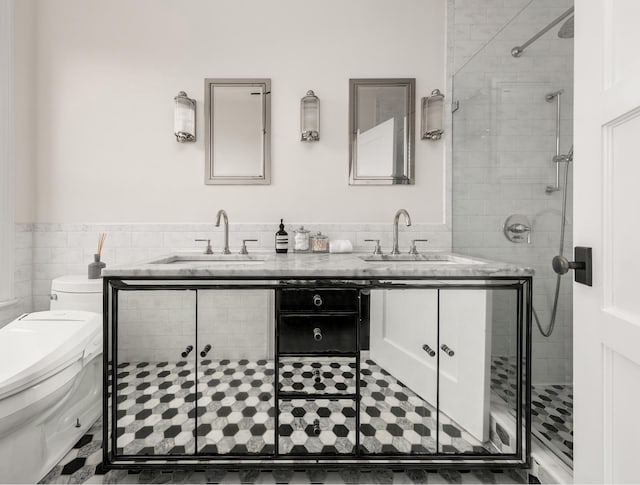 481 Macon St, New York City, NY 11233 - bathroom featuring toilet, wainscoting, a stall shower, tile walls, and double vanity