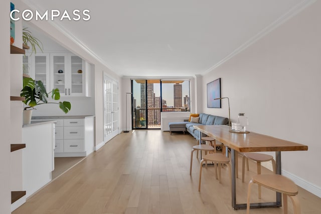 171 E 84th St Unit 22C, New York City, NY 10028 - dining area with ornamental molding, light wood-type flooring, expansive windows, and baseboards